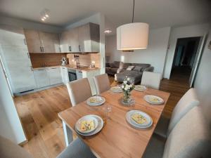 a dining room table with chairs and a kitchen at SeeZeitApartments Whg 30 in Lembruch