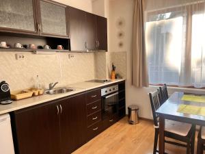 eine Küche mit einem Waschbecken und einem Tisch mit einem Esszimmer in der Unterkunft St. Anastasia Apartments in Bansko