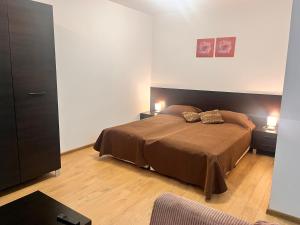 ein Schlafzimmer mit einem Bett mit zwei Tischen und zwei Lampen in der Unterkunft St. Anastasia Apartments in Bansko