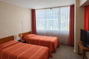 una camera d'albergo con due letti e una televisione di Hotel de Viña a Viña del Mar