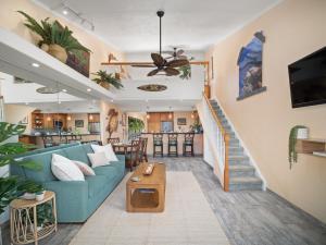 een woonkamer met een blauwe bank en een trap bij Top-floor corner unit across from the ocean at Kahana Villas (West Maui) in Kapalua-West Maui Airport