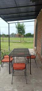 un tavolo da picnic con sedie e un campo sullo sfondo di El buho a Roldán Altre 6 foto