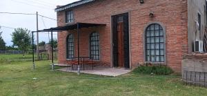 un edificio in mattoni con un tavolo da picnic di fronte di El buho a Roldán