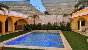 een zwembad in een tuin met een persoon erin bij Hotel Villa Chucum in Tikuch