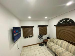 een woonkamer met een bank en twee ramen bij Still Point Guesthouse in Crown Point