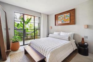 a bedroom with a large bed and a large window at ALMA Surf Lodge in Punta Mita +49 photos