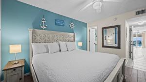 a bedroom with a white bed and a blue wall at Romar Tower 1B in Orange Beach +39 photos