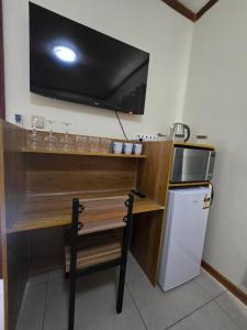 eine Küche mit einem Schreibtisch, einem TV und einem Kühlschrank in der Unterkunft Bula Lodge Guest House in Nadi