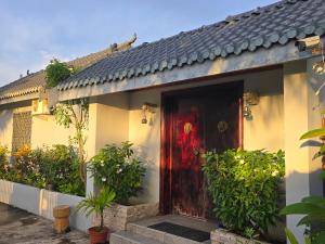 a house with a red door and some plants at Bula Lodge Guest House in Nadi