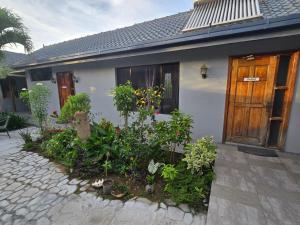 ein Haus mit Holztür und einigen Pflanzen in der Unterkunft Bula Lodge Guest House in Nadi + 12 Fotos