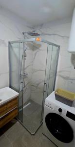 een douche met een glazen omhulsel in een badkamer bij North & South Escape Kolašin in Kolašin +1 foto