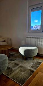 een woonkamer met een bank en een raam bij North & South Escape Kolašin in Kolašin