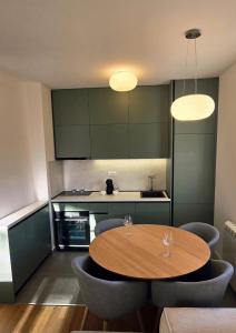 een keuken met een houten tafel en blauwe stoelen bij North & South Escape Kolašin in Kolašin