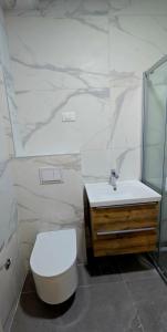 een witte badkamer met een toilet en een wastafel bij North & South Escape Kolašin in Kolašin
