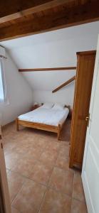 a small bedroom with a bed in a attic at duplex appartement 6 à 8 personnes in Guchan