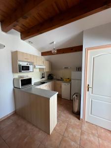 a kitchen with white appliances and a counter top at duplex appartement 6 à 8 personnes in Guchan