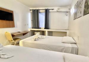 una camera d'albergo con 2 letti, scrivania di Manacá Hotel a Foz do Iguaçu