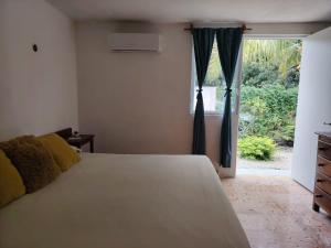 ein Schlafzimmer mit einem weißen Bett und einem Fenster in der Unterkunft Casa Nido Bacalar in Bacalar