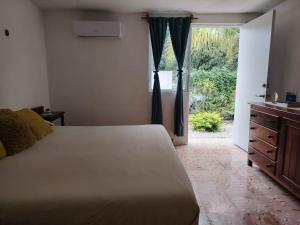 ein Schlafzimmer mit einem Bett, einer Kommode und einem Fenster in der Unterkunft Casa Nido Bacalar in Bacalar + 45 Fotos