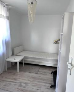 een witte kamer met een bank en een tafel bij Przy PKP in Biała Podlaska
