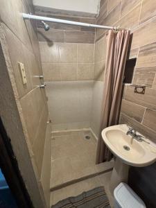 een badkamer met een douche en een wastafel bij Casa Guacamaya in Izamal