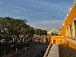 een uitzicht op een straat met een geel gebouw bij Casa Guacamaya in Izamal +7 foto's