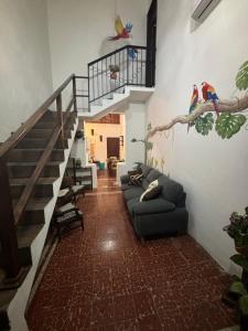 een woonkamer met een bank en een trap bij Casa Guacamaya in Izamal