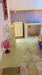 een kamer met een tafel, een stoel en een vloer bij Villa Romaine in Toubab Dialaw