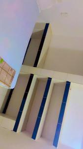 een kamer met blauw-witte balken aan het plafond bij Villa Romaine in Toubab Dialaw