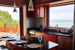 a kitchen with a view of the ocean at Villa Tea Tea in Papetoai +30 photos