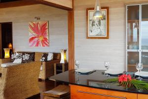 a dining room with a table with two wine glasses at Villa Tea Tea in Papetoai