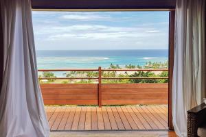 a room with a view of the ocean from a balcony at Villa Tea Tea in Papetoai