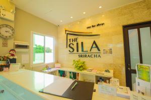 a office with a desk and a sign on the wall at The Sila Hotel in Si Racha