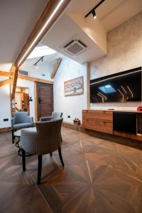 a living room with a large flat screen tv and chairs at Stella Di Notte City Center Studios in Belgrade