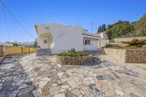 ein Haus mit einem steinernen Gehweg vor einem Gebäude in der Unterkunft Villa Casa Alice by Villa Plus in Carvoeiro