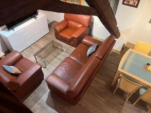 an overhead view of a living room with leather furniture at Duplex rénové avec terrasse privative à 10 mm de Colmar et Eguisheim, à 2 mm du grand axe autoroutier Strasbourg Mulhouse in Sainte-Croix-en-Plaine +17 photos