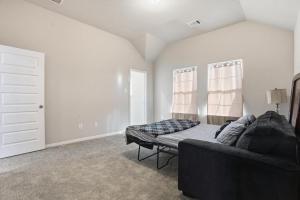 ein Wohnzimmer mit Sofa und Bett in der Unterkunft Near Lake Conroe • Private Yard • Pet Friendly in Keenan