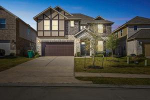 ein großes Backsteinhaus mit Garage im Hof in der Unterkunft Near Lake Conroe • Private Yard • Pet Friendly in Keenan