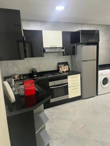 a kitchen with a black counter top and a refrigerator at Apartment in the center of Casablanca opposite the tram in Casablanca