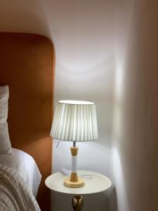 a lamp on a table next to a bed at Apartment in the center of Casablanca opposite the tram in Casablanca