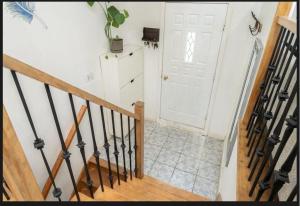 a hallway with a white door and a staircase with a stair case at Private Bed Room in a Beautiful Family House in Brossard