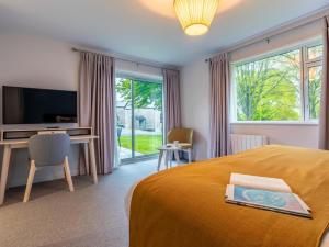 a bedroom with a bed and a desk and a television at 2 Bed in Saltash oc-87713 in St. Mellion
