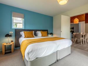 a bedroom with a large bed with blue walls at 3 Bed in Saltash oc-87711 in St. Mellion +15 photos