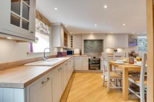 een keuken met witte kasten en een houten tafel bij 3 Bed in Bala oc-bow69 in Bala