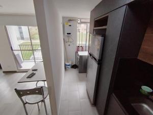a small kitchen with a table and a refrigerator at Confortable Apartamento cerca Aerop JMC in Rionegro +31 photos