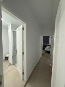 a hallway with white walls and a door to a room at La posada del sur in San Bartolomé de Tirajana