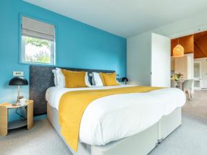 a bedroom with a large bed with yellow and blue walls at 3 Bed in Saltash oc-87717 in St. Mellion +21 photos