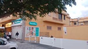 a woman walking in front of a building at Urban Stay Maspalomas in San Bartolomé