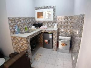 a miniature kitchen with a sink and a stove at Résidence hibis chez M&B in Saly Portudal +16 photos