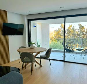 een woonkamer met een tafel en stoelen en een groot raam bij The L Smart Suite in Ierápetra